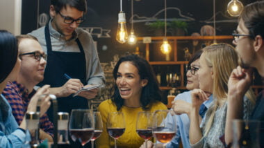 In,the,bar/,restaurant,waiter,takes,order,from,a,diverse