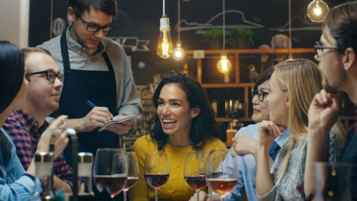In,the,bar/,restaurant,waiter,takes,order,from,a,diverse