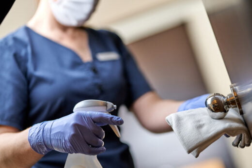 Maid,in,mask,doing,disinfecting,the,door,handle,in,hotel