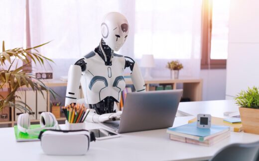 A,humanoid,robot,works,in,an,office,on,a,laptop,