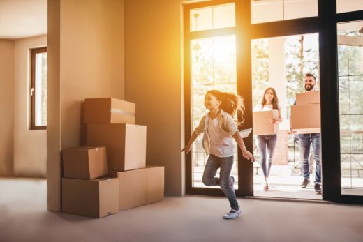 Happy,family,with,cardboard,boxes,in,new,house,at,moving