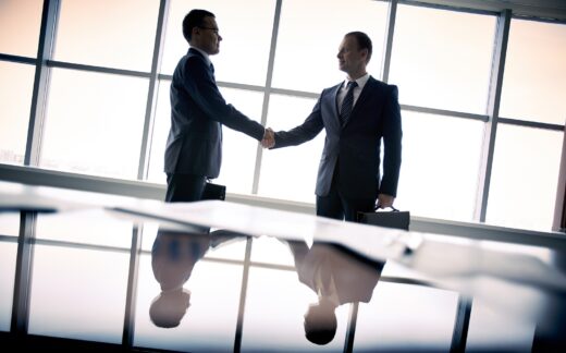 Silhouettes,of,two,businessmen,standing,by,the,window,and,handshaking