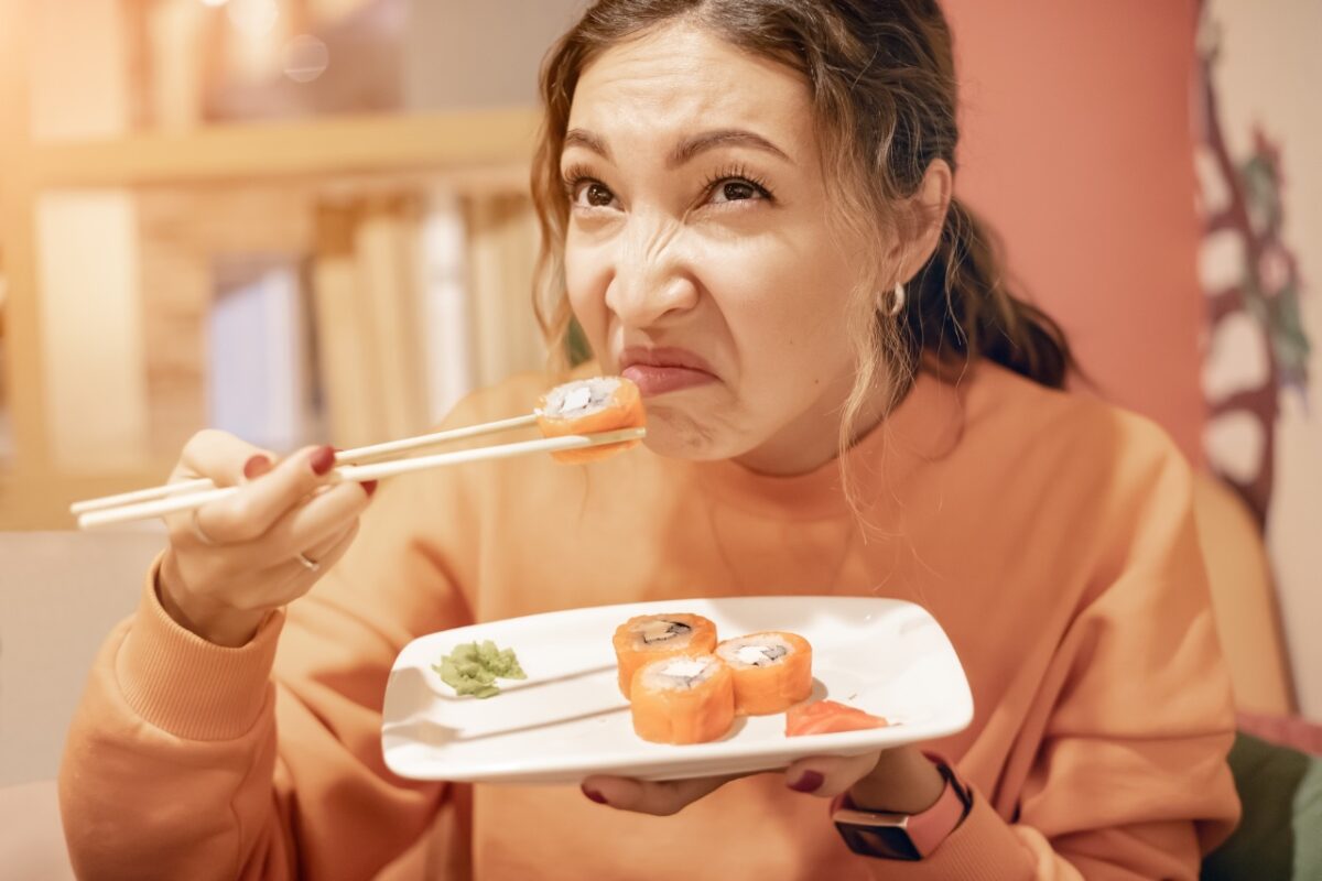 A,woman,sniffs,a,spoiled,sushi,roll.,the,danger,of