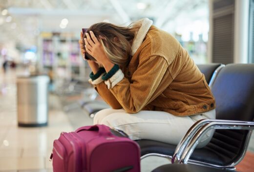 Upset,woman,,airport,and,flight,delay,sitting,on,bench,in
