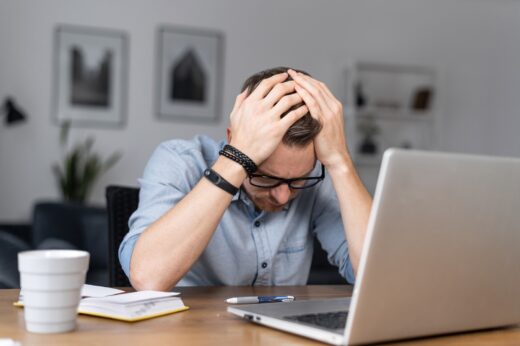Depressed,young,businessman,holding,head,in,hands,,has,problem,,a