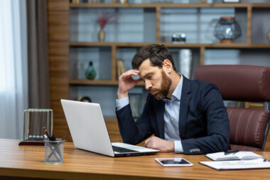 Sad,and,depressed,businessman,in,depression,working,inside,modern,office