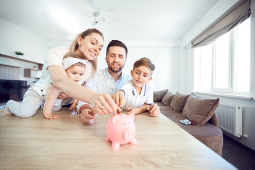 A,smiling,family,saves,money,with,a,piggy,bank.