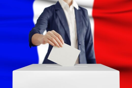 Woman,putting,a,ballot,into,a,voting,box,with,french