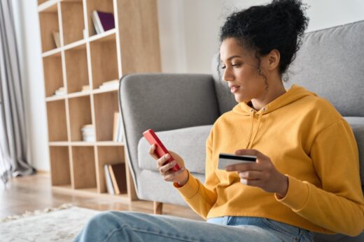 Young,adult,african,american,female,consumer,holding,credit,card,and